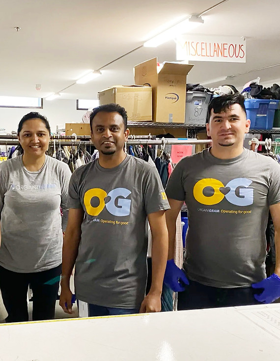 A photograph of three Organigram employees wearing matching Organigram t-shirt while taking part in a local volunteer event in Moncton