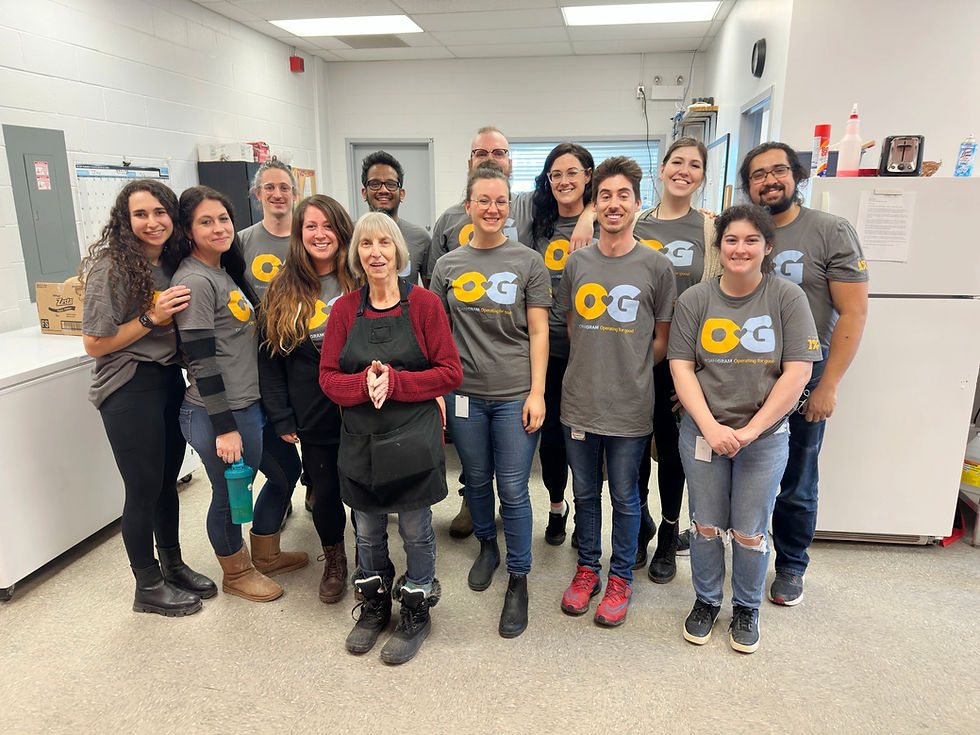 A group of Organigram employees wearing Operating for Good shirts and smiling.